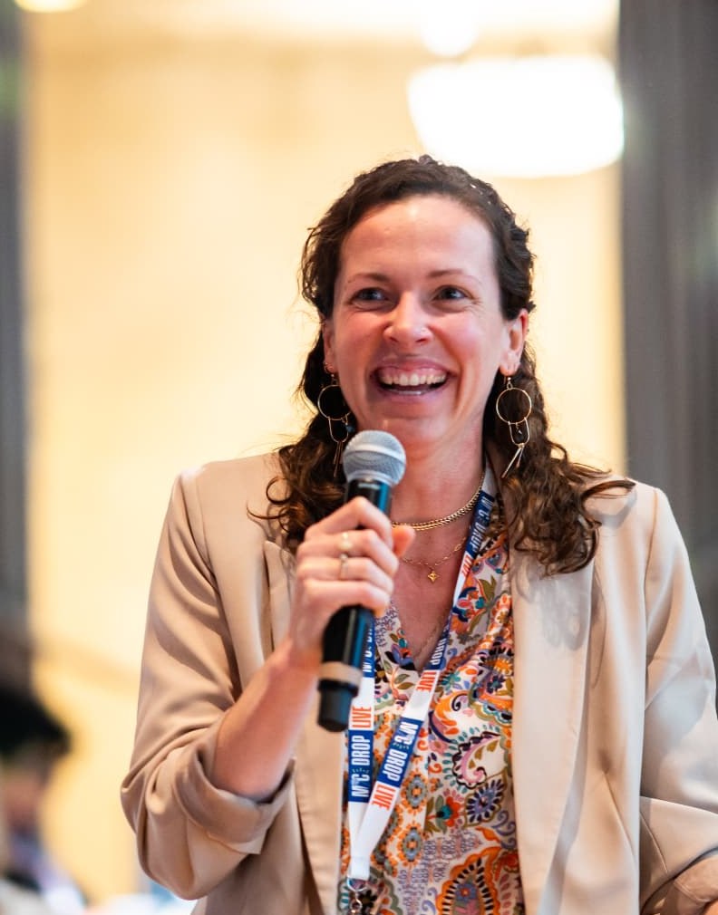 Brittany Martin Déjean laughing with a microphone while speaking to a conference audience